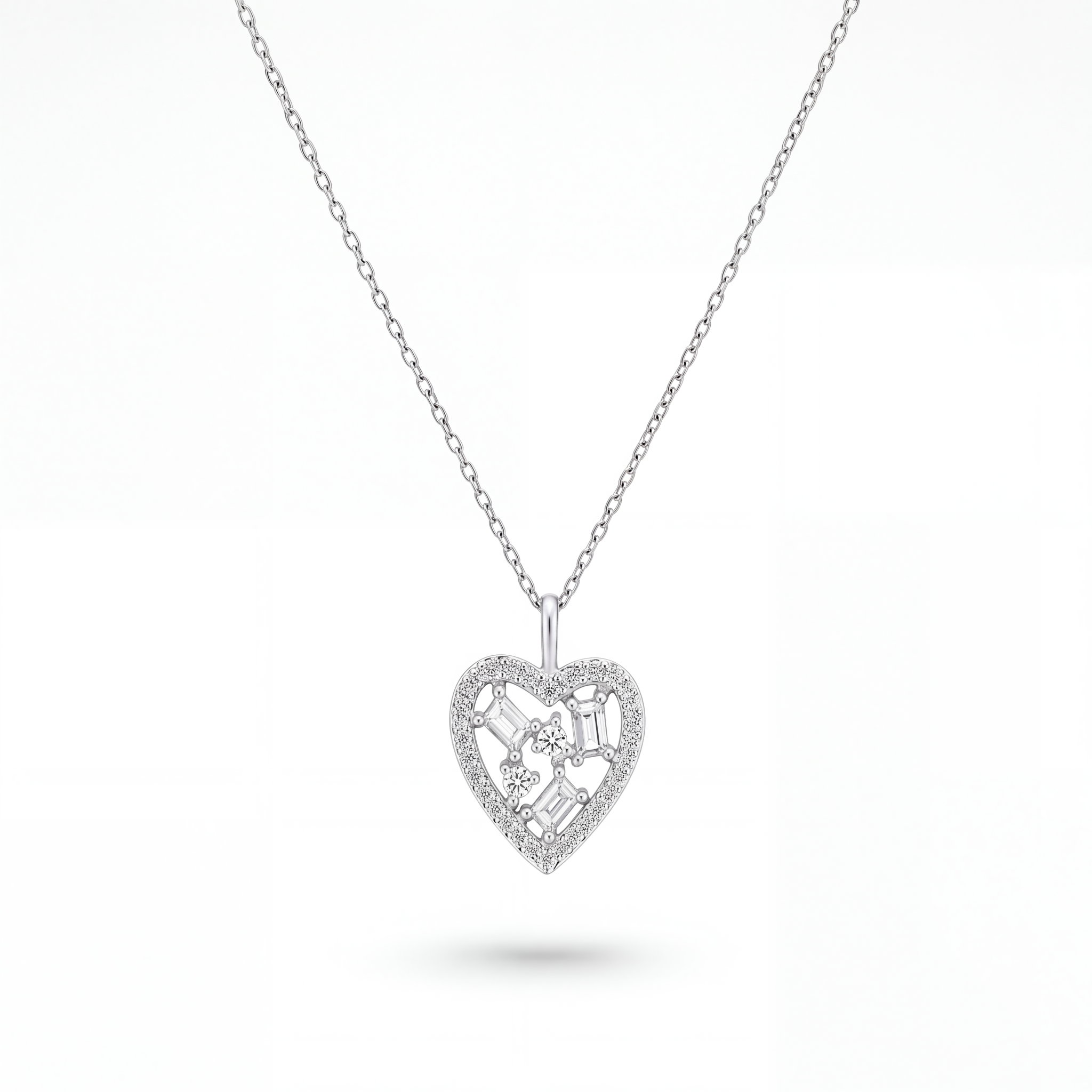 A silver heart-shaped pendant necklace with a delicate chain, featuring a central floral motif and small clear stones, shown on a clean white background.