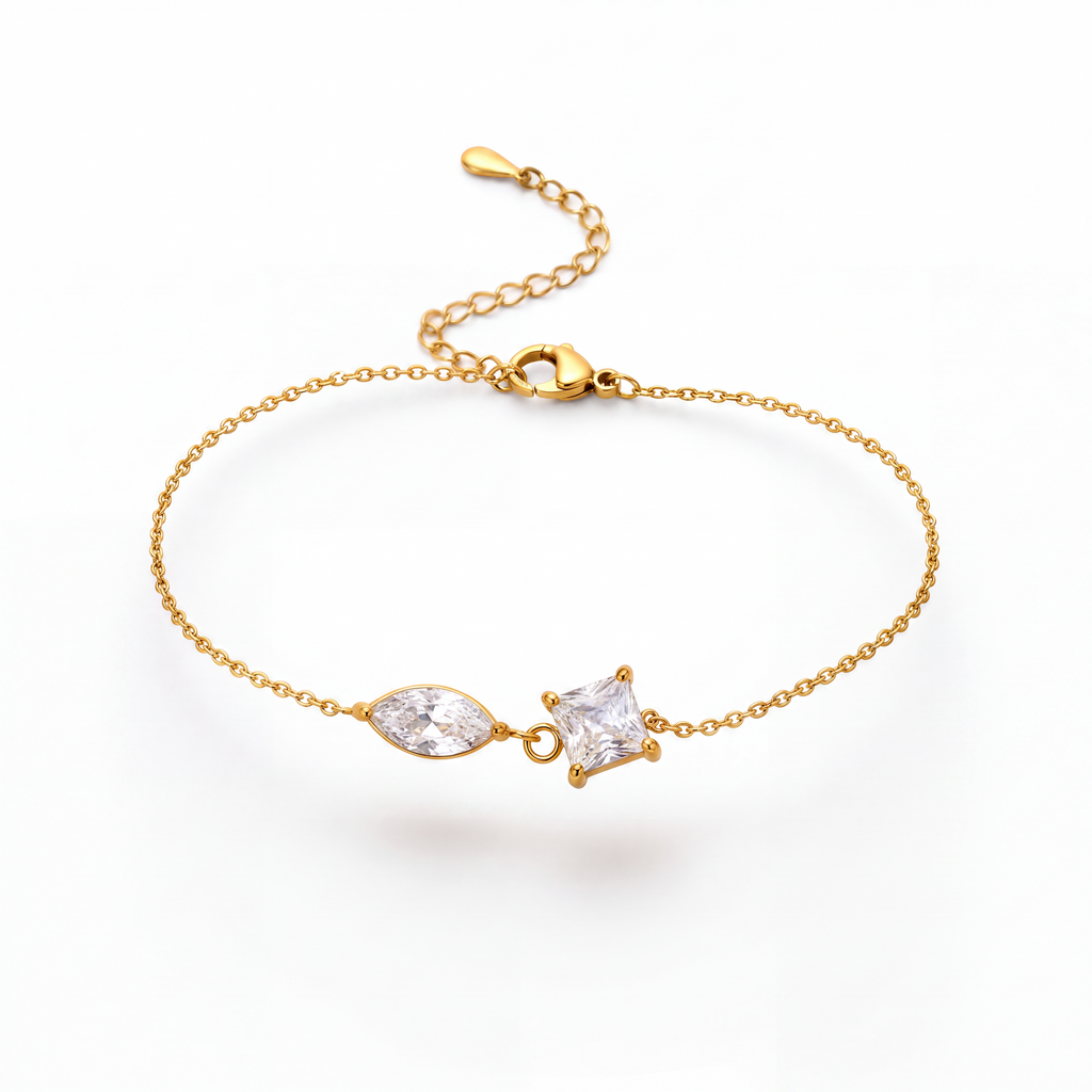 A delicate gold chain bracelet featuring a marquise-cut clear gemstone and a small triangular clear gemstone set in gold, displayed on a clean white background.