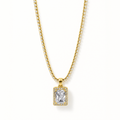 A gold chain necklace with a rectangular emerald-cut clear center stone and a halo of small clear stones, shown on a clean white background.