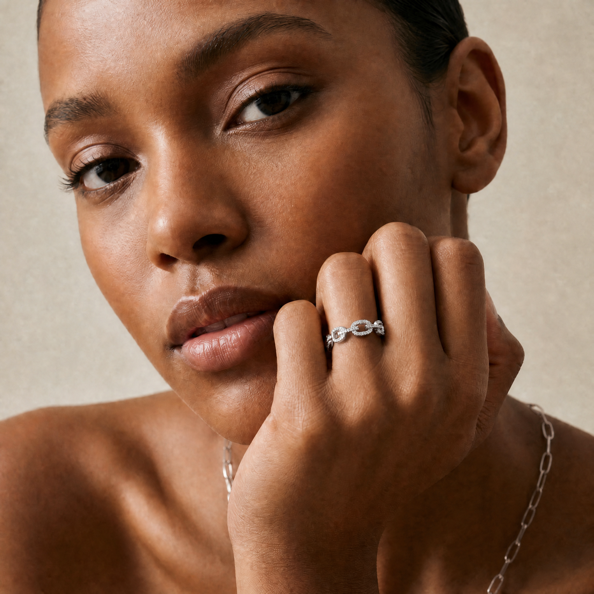 Woman wearing gold jewelry with a neutral background